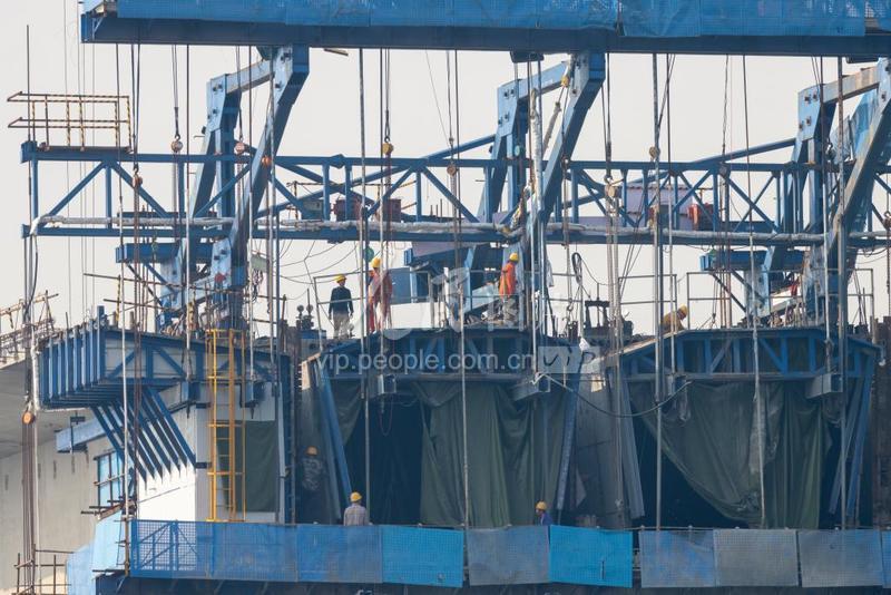 2月22日，重庆三环高速公路合川至长寿段龙溪嘉陵江特大桥建设现场，工人们正在绑钢筋、模板施工。