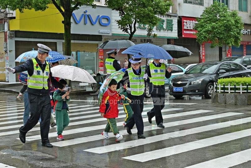 湖南洞口:交警为雨中上学孩子撑起“安全伞”-人民图片网